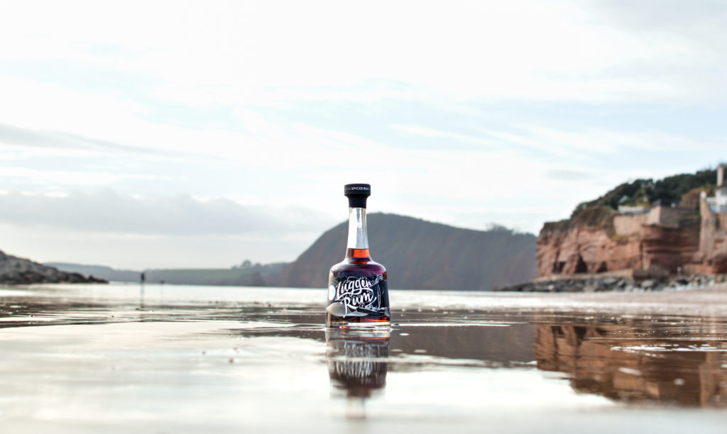 Lugger Rum on sand with Lyme Bay coast in the background
