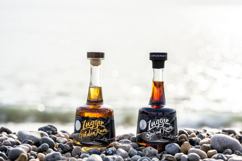 Lugger Rum and Golden Lugger on a pebble beach