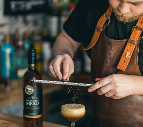 A barman grating nutmeg over a Lyme Bay mead cocktail